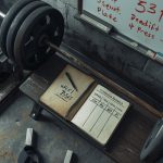 Продвинутый атлет выполняет приседания со штангой по программе тренировок 5/3/1 Джима Вендлера в тренажерном зале